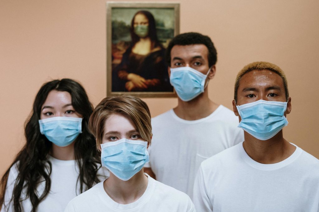 four people wearing masks